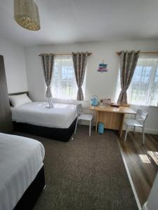 sypialnia z 2 łóżkami, biurkiem i stołem w obiekcie Cozy Room,Private Bathroom,Private Kitchynete w Dublinie