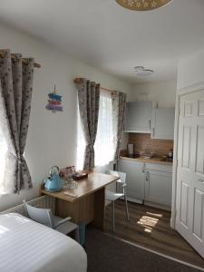 Cet appartement comprend une chambre avec un lit et une table ainsi qu'une cuisine. dans l'établissement Cozy Room,Private Bathroom,Private Kitchynete, à Dublin
