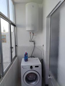 a laundry room with a washing machine and a window at Casa da laranjeira in Montargil