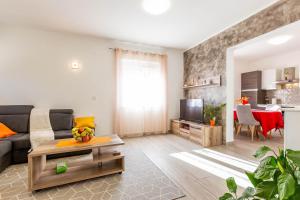 a living room with a couch and a table at Chubi 2BR apt parking terrace bbq vegetable garden in Zadar