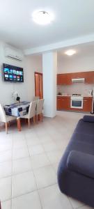 - un salon avec un canapé, une table et des chaises dans l'établissement Apartments Burazer, à Šibenik