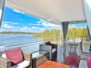 a balcony on a boat with a table and chairs at House of Bell - Vaal River in Vanderbijlpark