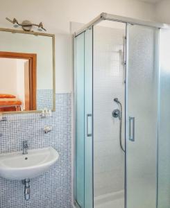 a bathroom with a sink and a glass shower at Hotel Pineta in San Menaio