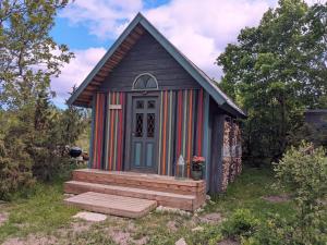un pequeño cobertizo con porche y puerta en MUHUSI Linnumaja en Igaküla