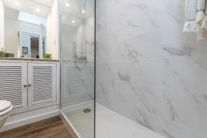 uma casa de banho branca com um chuveiro e um WC. em Ribeira Art Terrace no Porto