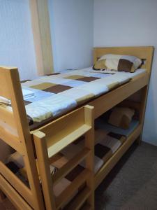 a wooden bunk bed in a room with a ladder at Vikendica Ribnik 