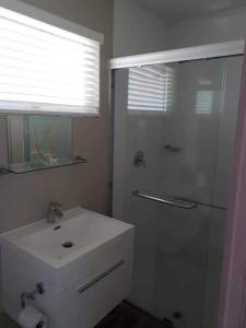 biała łazienka z prysznicem i umywalką w obiekcie House of Bell - Vaal River w mieście Vanderbijlpark