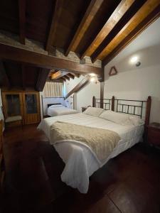 two large beds in a room with wooden ceilings at Posada El Valle - Adults Only in Suances