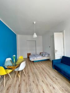 a living room with a blue couch and a table and chairs at Blue Dollar Apartament in Przemyśl