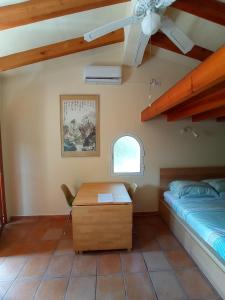 een slaapkamer met een bed en een bureau in een kamer bij Casita de la Cumbre - Studio near Cala Moraig in Benitachell