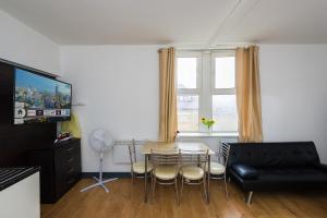 uma sala de estar com uma mesa e cadeiras e um sofá em Snooze Apartments em Bradford