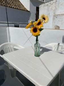 een vaas gevuld met zonnebloemen zittend op een tafel bij Casa Ana in Vejer de la Frontera