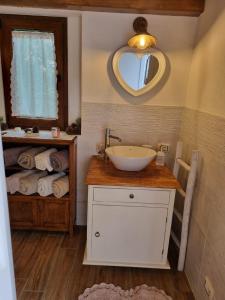 een badkamer met een wastafel, een spiegel en handdoeken bij Casa Toscana in Lorenzana
