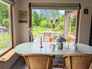 a dining room with a table and chairs and a window at MUHUSI Linnumaja in Igaküla