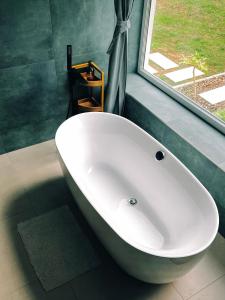 巴拉頓菲茲弗的住宿－Bambusz apartman，带窗户的浴室内的白色浴缸