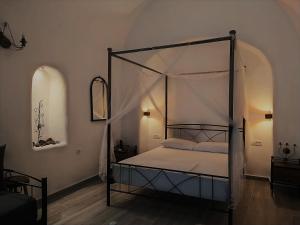 a bedroom with a bed with a canopy at Mentoras' Complex in Emporio Santorini