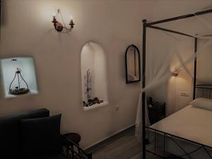a bedroom with a bed and a mirror on the wall at Mentoras' Complex in Emporio Santorini