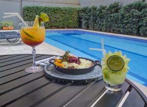 a table with a bowl of food and a drink next to a pool at Wyndham Sao Paulo Paulista in Sao Paulo