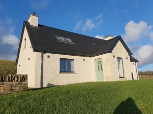 a large house with a green lawn in front of it at Redland Cottage in Orkney