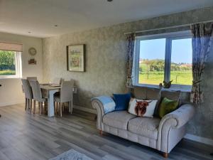 a living room with a couch and a table at Redland Cottage in Orkney