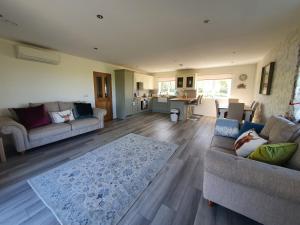 sala de estar con 2 sofás y cocina en Redland Cottage en Orkney