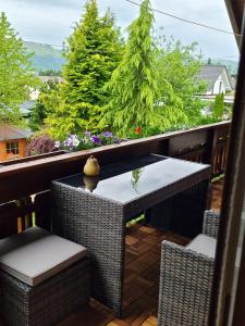 - un balcon avec une table, des chaises et des arbres dans l'établissement Haus Flora - Ferienwohnung Bodensdorf, à Bodensdorf