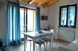 einen Esstisch und Stühle in einem Zimmer mit Fenstern in der Unterkunft Casa Bellavista in Porlezza