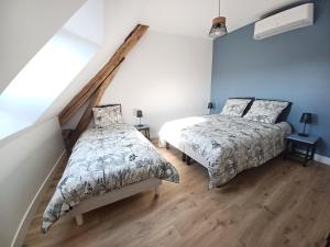 2 camas en un dormitorio con paredes azules y suelo de madera en Rêve de Loire chambres d'hôtes au calme au pied des châteaux de la Loire en Onzain