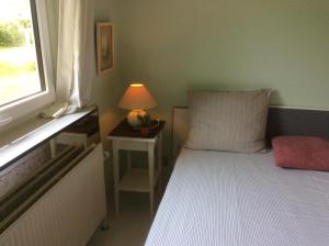 - une chambre avec un lit doté d'une lampe et d'une fenêtre dans l'établissement Very Nice villa in Rødby, à Rødby