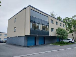 duży budynek z niebieskimi drzwiami na parkingu w obiekcie Ristimäenkatu w mieście Mikkeli