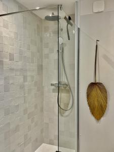 een badkamer met een douche en een glazen deur bij LE BALI, Exceptionnel P3 avec piscine à 2 min des plages , parking, wifi et climatisation in La Grande-Motte