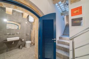 a bathroom with a blue door and a staircase at Vallettastay Standard Apartments in Valletta in Valletta