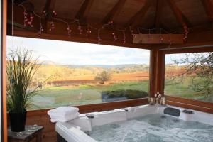 bañera en una habitación con ventana grande en Domaine du Mas Naut, en Conques-en-Rouergue