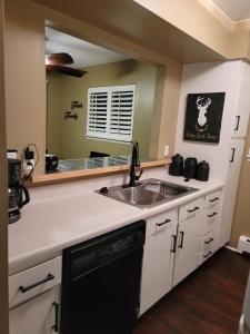 a kitchen with a sink and a dishwasher at Mountain View Lodging Cody in Cody