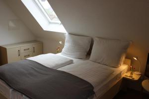 a bedroom with a bed with white sheets and a window at Fränkische Seenliebe in Gunzenhausen
