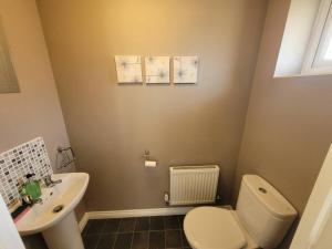 a bathroom with a white toilet and a sink at Kensington House- The Perfect home for contractor stays in Colchester