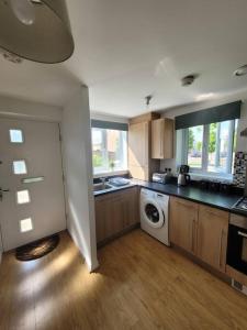 a kitchen with a sink and a washing machine at Kensington House- The Perfect home for contractor stays in Colchester