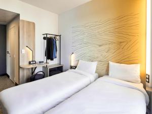 アルジャントゥイユにあるB&B HOTEL Argenteuilのベッド2台が隣同士に設置された部屋です。