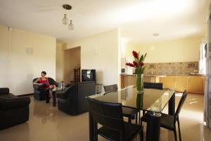 ein Wohnzimmer mit einem Tisch und einer Frau auf einer Couch in der Unterkunft Jet Villa in Flic-en-Flac