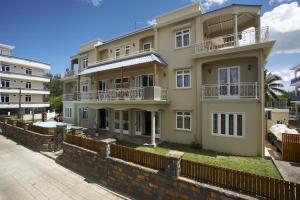 a large building with a fence in front of it at Jet Villa in Flic-en-Flac