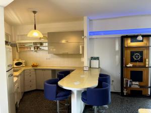 a kitchen with a table and blue chairs at Stunning View Seaside 1-Bed Apartment in Saronida in Saronida