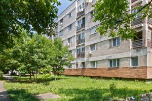 Un edificio de apartamentos con árboles en frente. en Sovata Studio, en Oradea