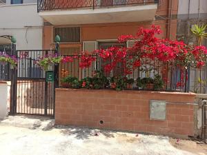 een smeedijzeren hek met bloemen erop bij Casa Otello in Siracusa