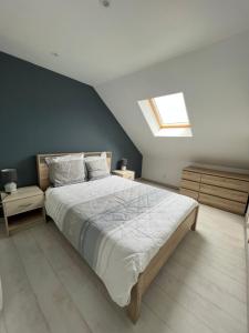 sypialnia z dużym łóżkiem i oknem dachowym w obiekcie Largo Bayeux w mieście Bayeux