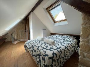 een slaapkamer met een bed op een zolder met een raam bij Au cœur du Bourg - La Celle St Cloud. in La Celle-Saint-Cloud