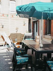 uma mesa e cadeiras com um guarda-sol num pátio em Appartement avec patio em Sainte Anne d'Auray