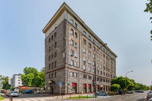 a tall brick building on a city street at Białobrzeska 22 by Homeprime in Warsaw