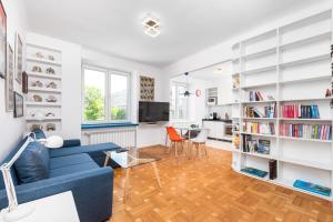 a living room with a blue couch and book shelves at Białobrzeska 22 by Homeprime in Warsaw