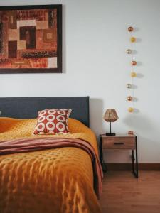 um quarto com uma cama com um cobertor laranja e um candeeiro em Appartement avec patio em Sainte Anne d'Auray