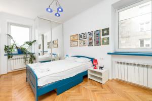 a bedroom with a blue bed and a window at Białobrzeska 22 by Homeprime in Warsaw